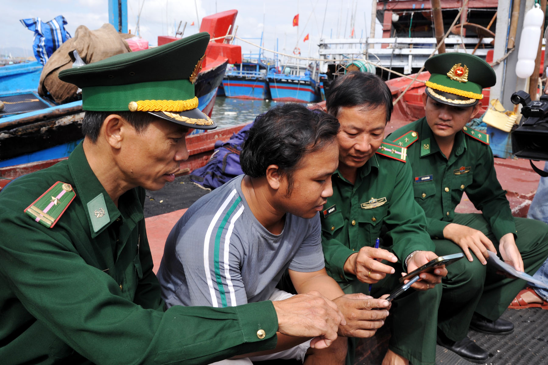 Đồn Biên phòng Tuy Hòa hướng dẫn ngư dân cập nhật trên điện thoại những phần mềm khai báo liên quan đến khai thác hải sản. Ảnh: ANH NGỌC