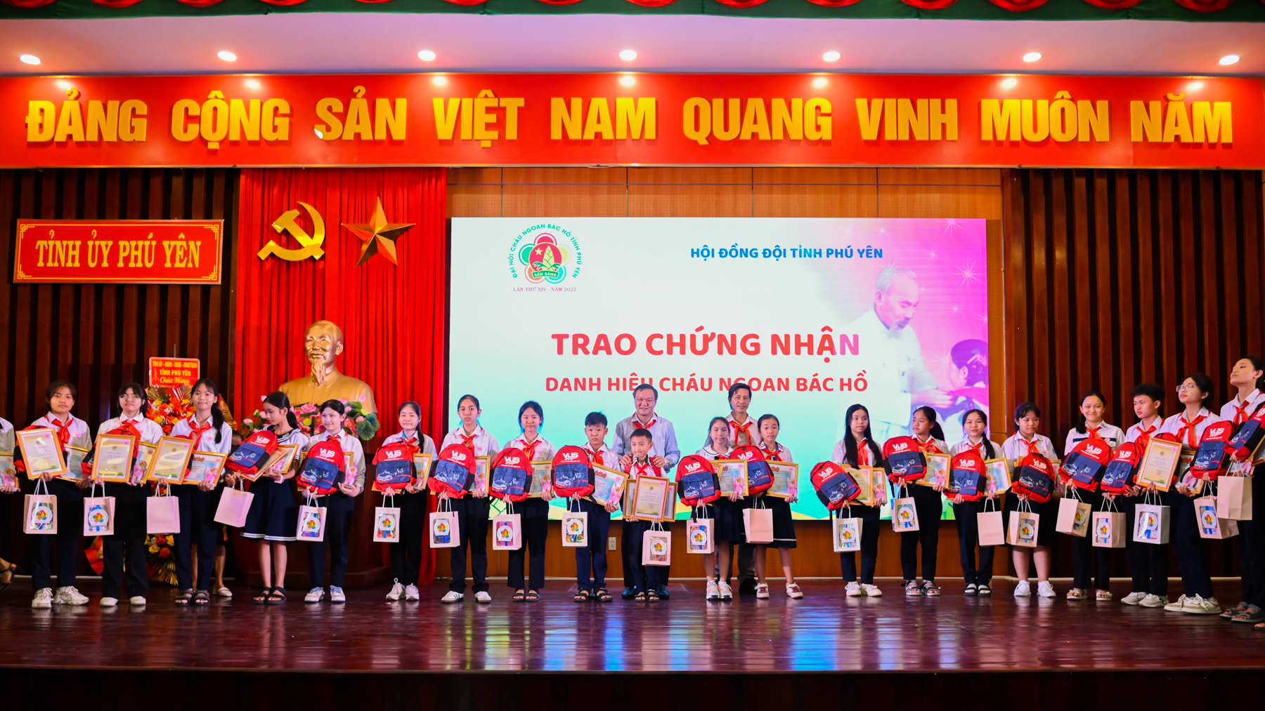 Phó Chủ tịch UBND tỉnh Đào Mỹ và Phó Chủ tịch Ủy ban MTTQ tỉnh Phạm Văn Bảy trao biểu trưng, chứng nhận danh hiệu Cháu ngoan Bác Hồ cấp tỉnh cho thiếu nhi. Ảnh: THẢO QUYÊN