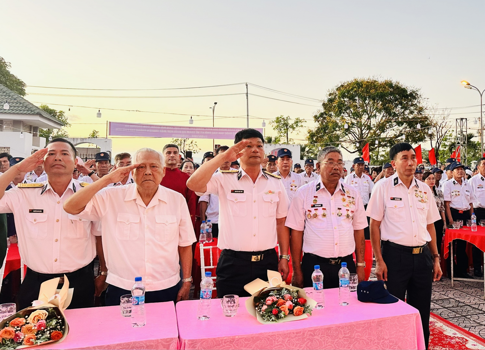 Anh hùng LLVT nhân dân Hồ Đắc Thạnh (thứ hai, bên trái) cùng các đại biểu thực hiện nghi thức chào cờ. Ảnh: YÊN LAN