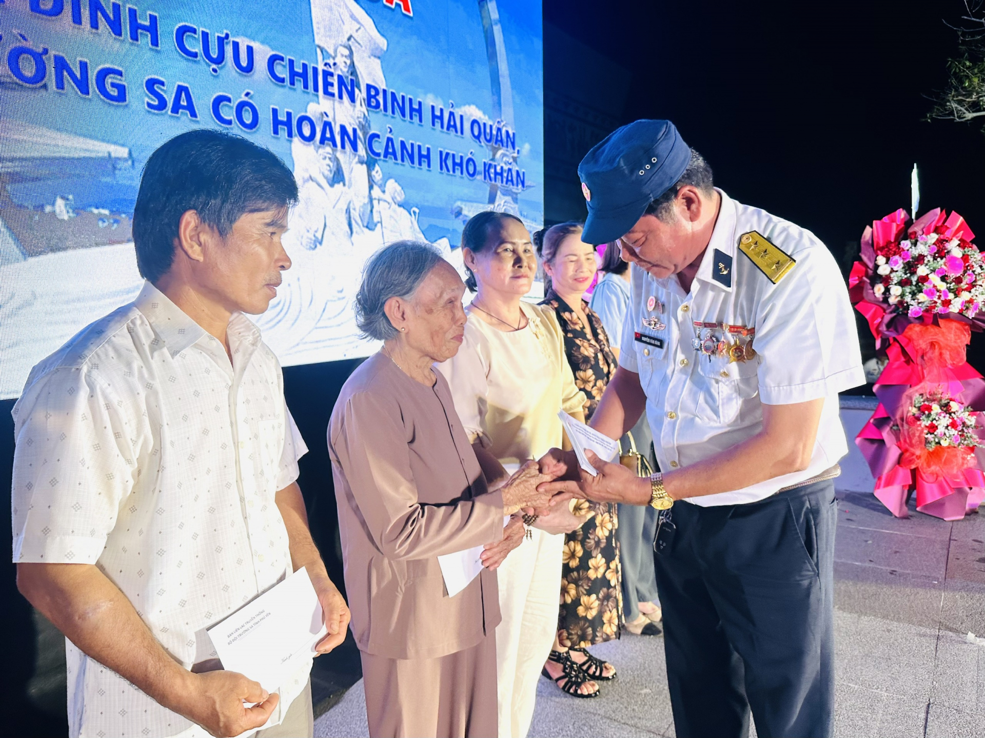 Cựu chiến binh Lê Thành Phương (ngoài cùng bên phải) tặng quà lưu niệm cảm ơn đại tá - Nghệ sĩ Ưu tú Hoàng Nguyên và cựu chiến binh Trần Văn Xuất. Ảnh: YÊN LAN