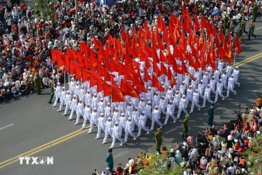 Khối cờ Đảng, cờ Tổ quốc diễu hành trên đường Nam Kỳ Khởi Nghĩa. Ảnh: TTXVN