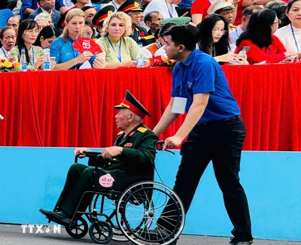 Thanh niên hỗ trợ đại biểu di chuyển trong khu vực diễu binh, diễu hành kỷ niệm 50 năm Ngày Giải phóng miền Nam, thống nhất đất nước. Ảnh: TTXVN