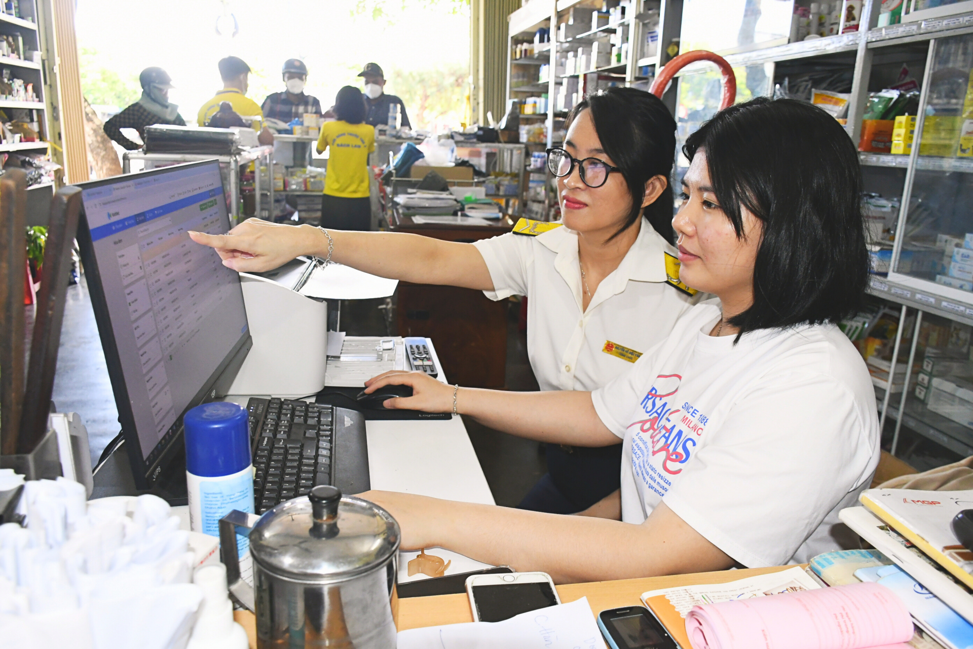 Cán bộ Đội Thuế TP Tuy Hòa hướng dẫn hộ kinh doanh xuất hóa đơn điện tử khởi tạo từ máy tính 
tiền kết nối chuyển dữ liệu điện tử với cơ quan thuế. Ảnh: VIỆT AN