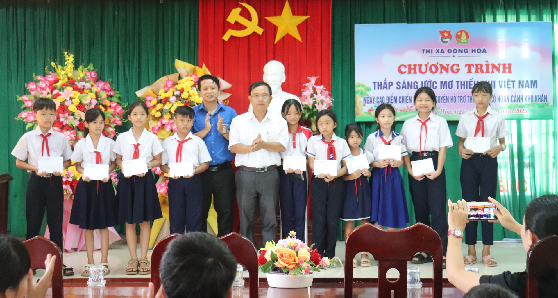Chủ tịch Ủy ban MTTQ TX Đông Hòa Nguyễn Thành Thân và Phó Bí thư Thị đoàn Lê Vũ Long trao học bổng cho các học sinh. Ảnh: MINH HUYỀN