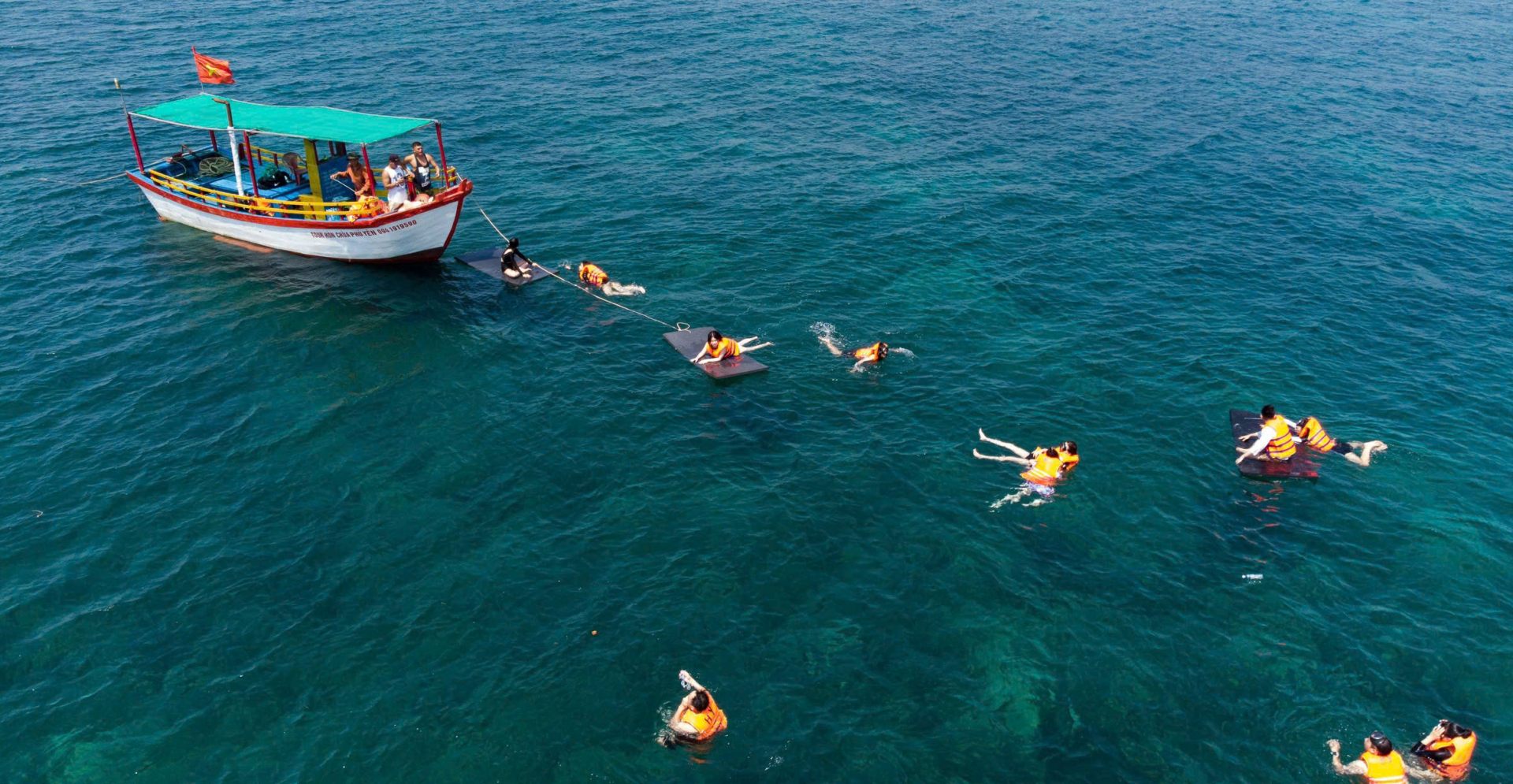 Visitors enjoying wearing life jackets, diving goggles to explore coral reefs at Hon Chua