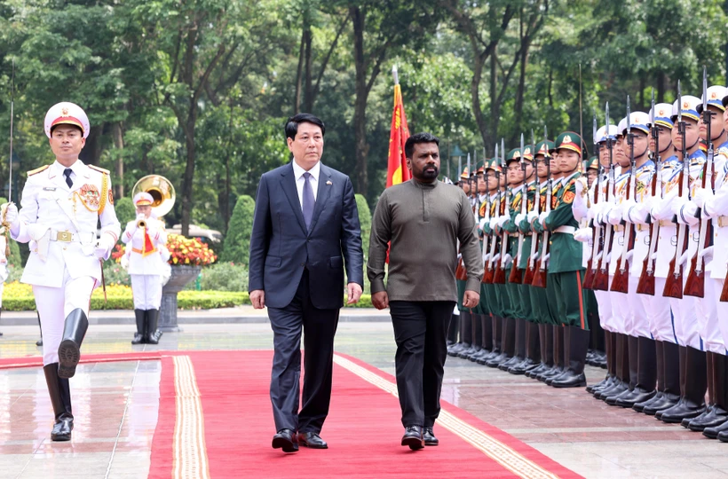 State President Luong Cuong (L) and Sri Lankan President Anura Kumara Dissanayaka review the guard of honour of the Vietnam People’s Army at the ceremony on May 5. Photo: VNA
