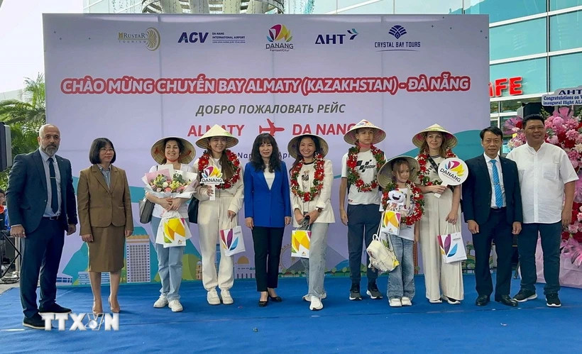Ban Tổ chức tặng hoa, quà cho các hành khách đầu tiên đến Đà Nẵng trên đường bay trực tiếp từ Kazakhstan. Ảnh: TTXVN