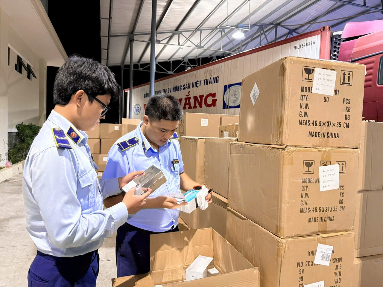 Lực lượng quản lý thị trường kiểm tra lô thiết bị điện tử đã tạm giữ tại kho. Ảnh: CTV
