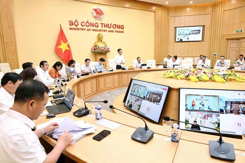 Minister of Industry and Trade Nguyen Hong Dien (standing) chairs a working session with major Vietnamese enterprises on May 7. Photo: VNA