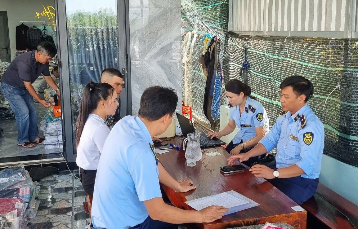 Cán bộ Đội Quản lý thị trường số 3 làm việc tại Cơ sở kinh doanh Thanh Hằng. Ảnh: CTV
