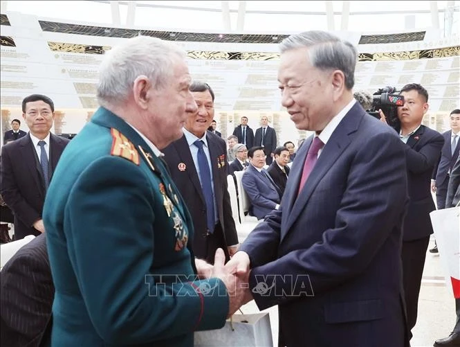 Party General Secretary To Lam shakes hands with a Belarusian veteran with outstanding contributions to Vietnam. Photo: VNA