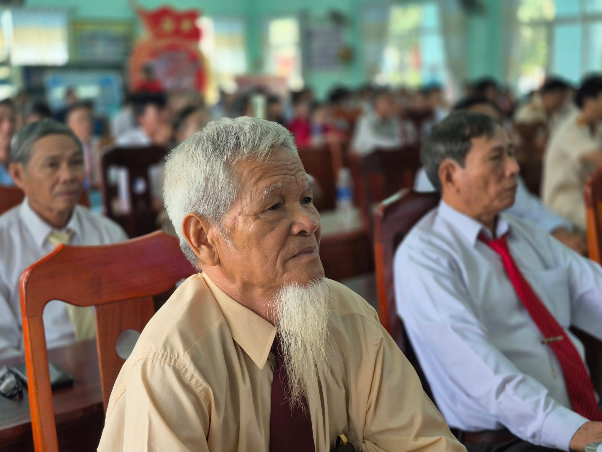 Ông Lưu Công Định, nguyên Chủ tịch UBND xã Hòa Đồng có mặt từ sớm và chăm chú theo dõi buổi lễ công bố sáp nhập Phú Yên - Đắk Lắk. Ảnh: THỦY TIÊN