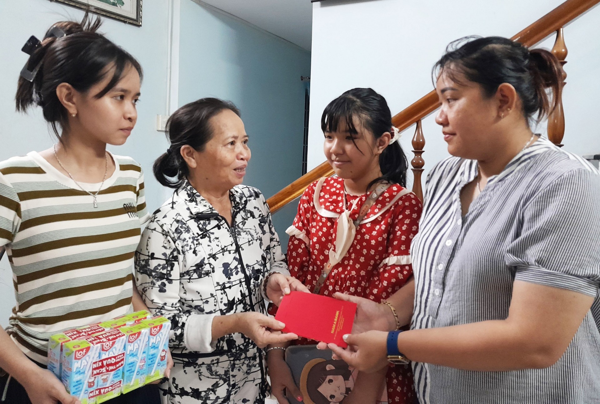 Chị Võ Hoàng Duyên, Trưởng Quỹ Tim ấm trao tiền, quà giúp đỡ gia đình bà Nguyễn Thị Nở. Ảnh: KIM LIÊN