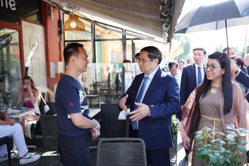 PM Pham Minh Chinh (centre) and his spouse visit the family of Vo Ba Luan - the owner of a restaurant in Nice. Photo: VNA