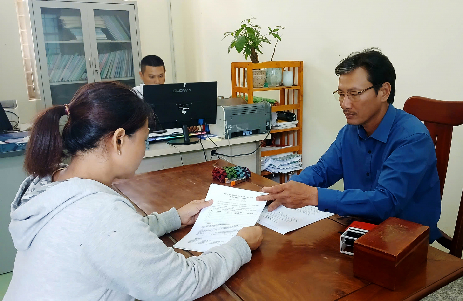 Người dân xã Ea Bá được cán bộ văn phòng UBND xã tiếp nhận hồ sơ giải quyết thủ tục hành chính ngay trong sáng 30/6. Ảnh: TRUNG HIẾU