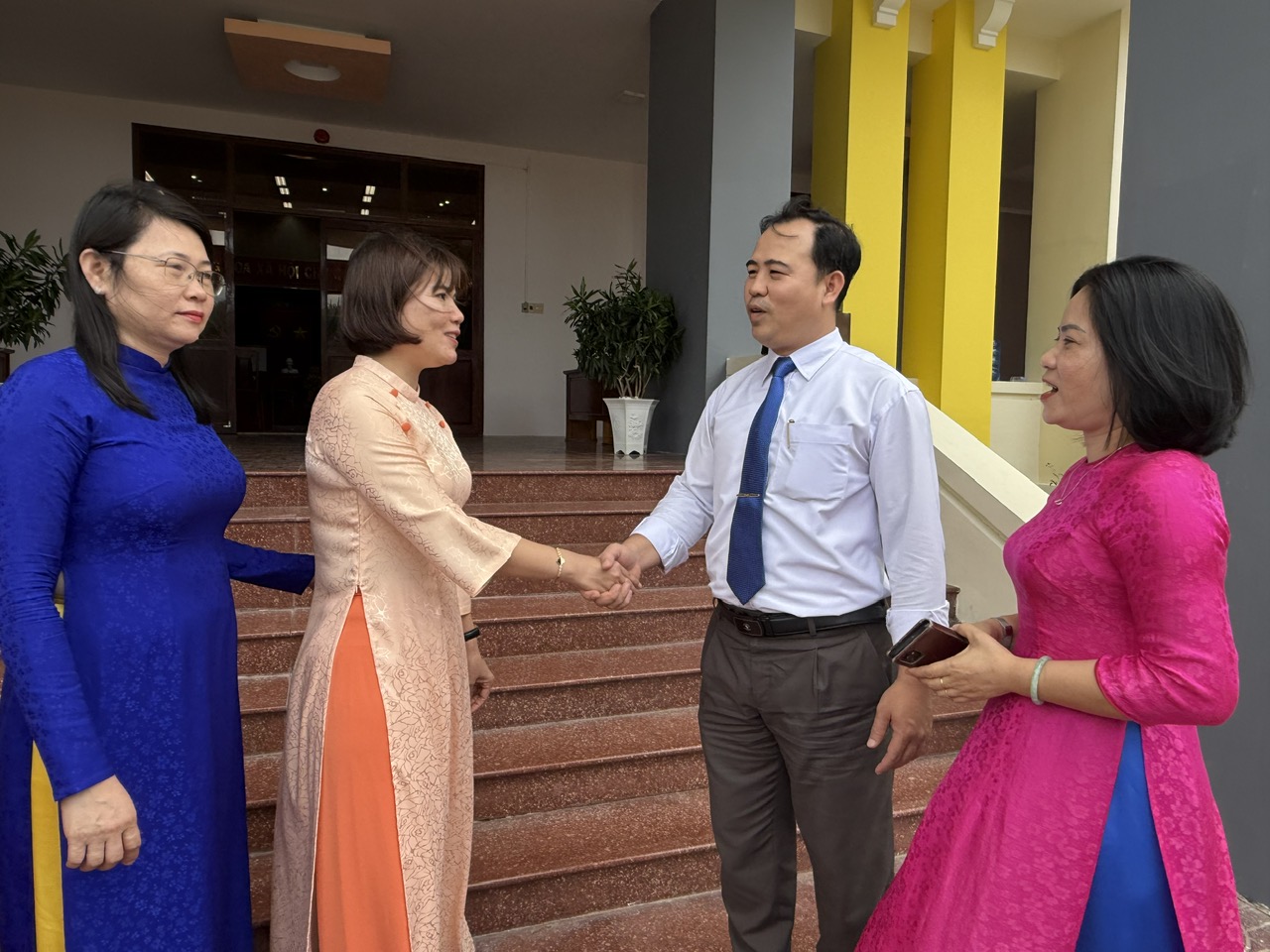 Phó Chánh Văn phòng Tỉnh ủy Phí Thị Mỹ Hậu và cán bộ xã Phú Hòa 1 trò chuyện trước thềm buổi lễ. Ảnh: NGỌC DUNG
