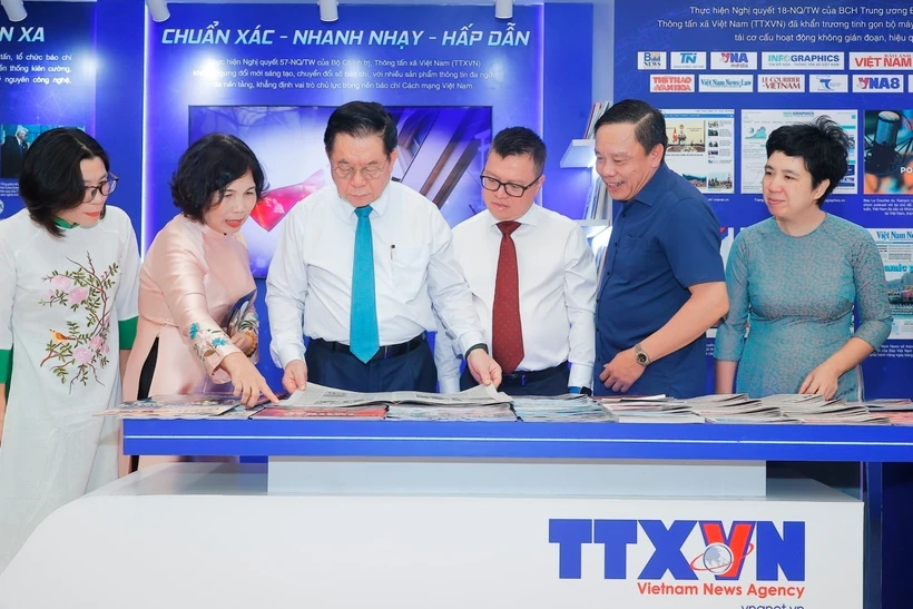 Politburo member and Chairman of the Party Central Committee’s Commission for Information, Education and Mass Mobilisation Nguyen Trong Nghia (third from left) visits the Vietnam News Agencys booth. Photo: VNA