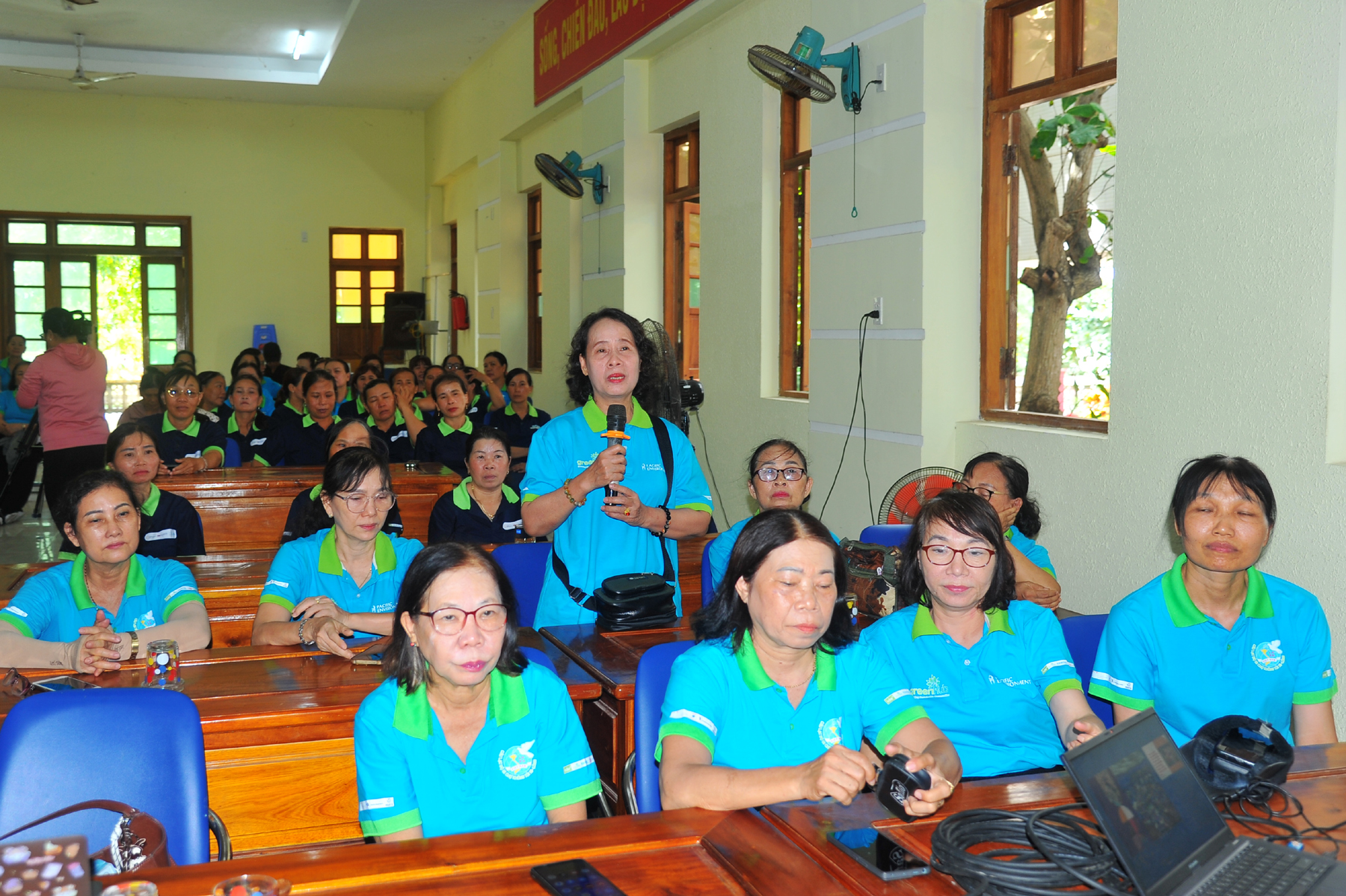 Đại diện câu lạc bộ Phụ nữ đi chợ không sử dụng túi ni lông chia sẻ kinh nghiệm phân loại rác tại nguồn và cách phân loại, xử lý rác tái chế. Ảnh: ANH NGỌC