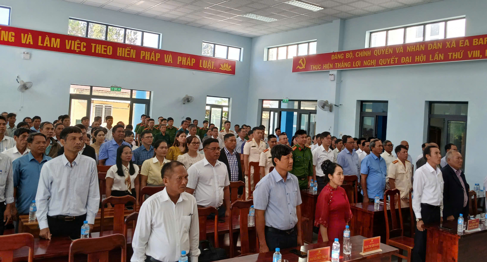 Cán bộ, công chức và người dân xã Ea Bá chào cờ tại trụ sở UBND xã khi dự lễ công bố sáp nhập hai tỉnh Phú Yên, Đắk Lắk. Ảnh: TRUNG HIẾU